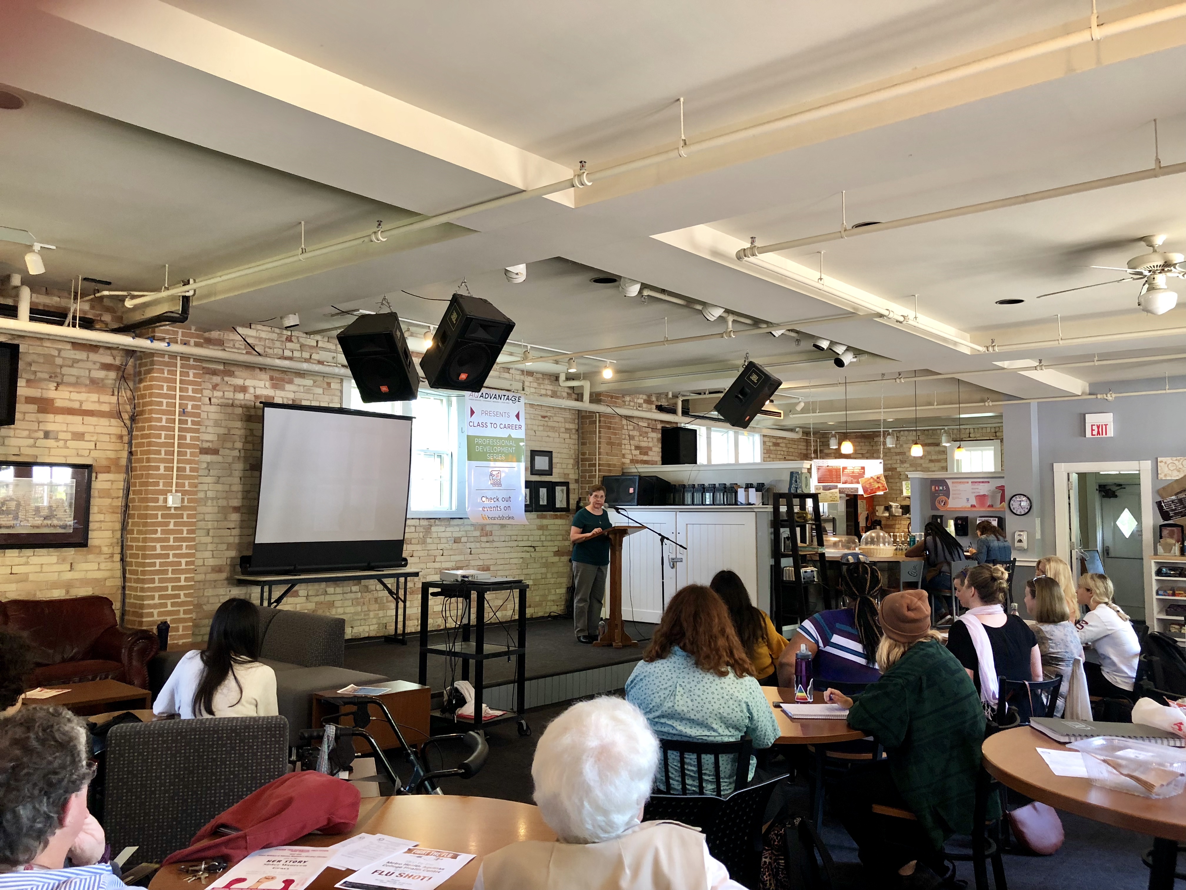 Sister Maureen Geary speaks to a group of people at the cook carriage house at Aquinas College.