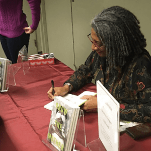Desiree Cooper signs a book for a student.